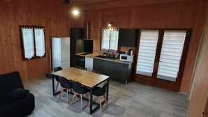 Une cuisine compacte comprenant une table et des chaises, un réfrigérateur, un four à micro-ondes et un évier.
