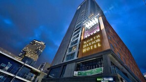 Hotel North Harbour, con un cartel llamativo, arquitectura moderna y vistas de los edificios circundantes.