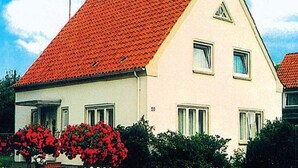 A two-story house with a red-tiled roof, white walls, and a small triangular window on the upper floor. - Vacation apartment Heimsoth Kappeln OG - Holiday apartments Heimsoth in Kappeln (Kappeln)