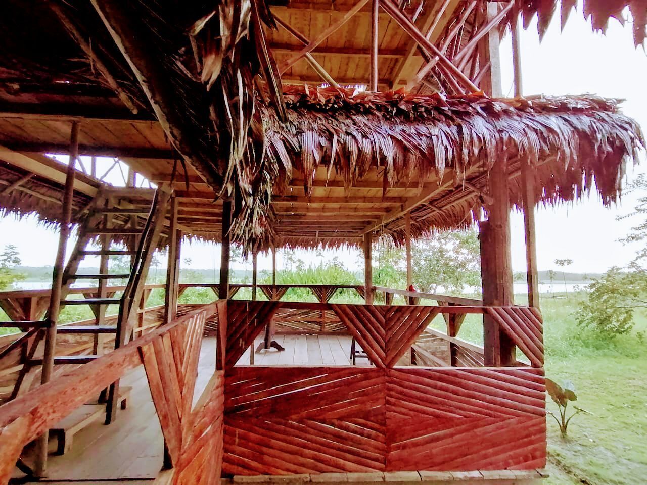 A wooden structure with a thatched roof and a wooden deck.