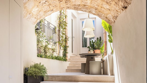 A staircase leading to a balcony with a table and chairs, surrounded by greenery and a stone archway. - Alma Suite - Two Bedroom Apartment, Sleeps 6 (Noto)