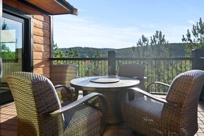Un balcon doté de meubles en osier et d’une porte vitrée.