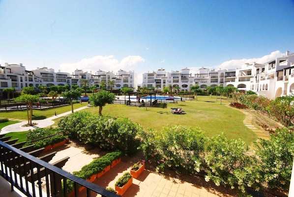 Un complejo residencial con varios edificios de apartamentos, césped cuidado y cielo despejado.
