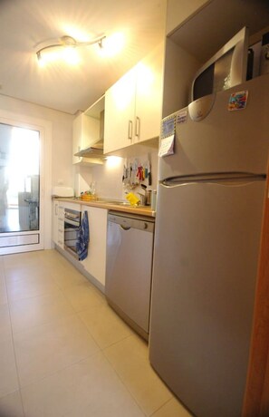 A kitchen with a refrigerator, oven, and dishwasher.