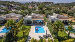 A modern hotel with multiple swimming pools, a covered outdoor area, and a view of the surrounding landscape. - Heated Private Pool★Brand New Lux villa★Walk to ALL★BBQ (Chania)