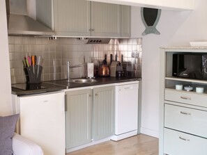 A modern kitchen with a stainless steel sink, a kettle, and a microwave. - L'appart de la Ferté - In the heart of Saint Valery's main street (Saint-Valery-sur-Somme)