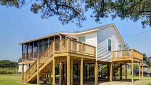 A two-story house with a wooden deck and a covered porch.