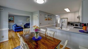 A modern kitchen with white cabinets, a built-in microwave, and a refrigerator. - Saltwater Therapy - Ocracoke Island (Ocracoke)