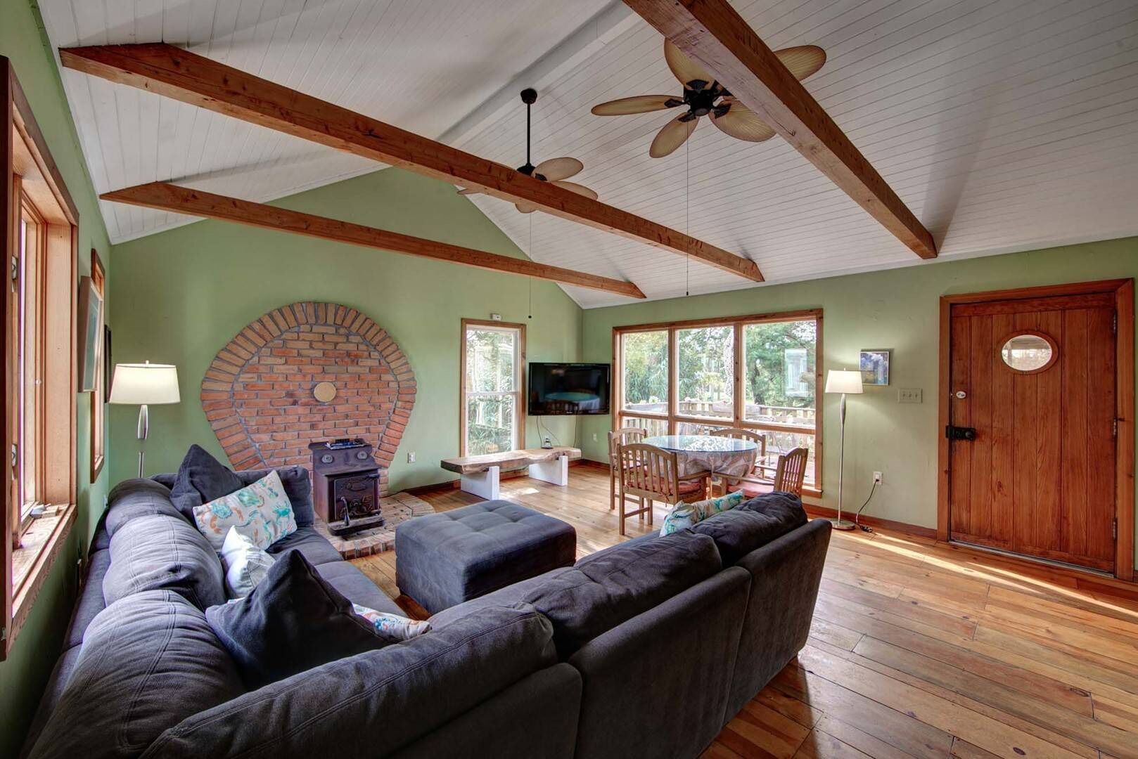 A cozy living room with a fireplace, a sofa, a TV, and a dining area.
