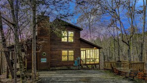 A rustic cabin with a wooden exterior, a porch, and a gravel driveway. - CEDAR KNOB - 2 bdrm/2 bath, screened patio, wood fireplace (Townsend)
