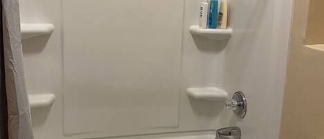 A bathroom with a bathtub, a toilet, and a shower curtain.