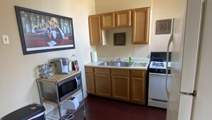 Una cocina con armarios de madera, un microondas, una estufa y un refrigerador.