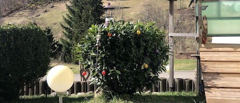 Ein Garten mit Teich, einer Holzterrasse und einem Haus im Hintergrund.
