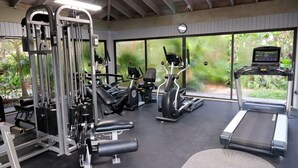 A gym with various exercise equipment, including a treadmill, elliptical, and weight machines.