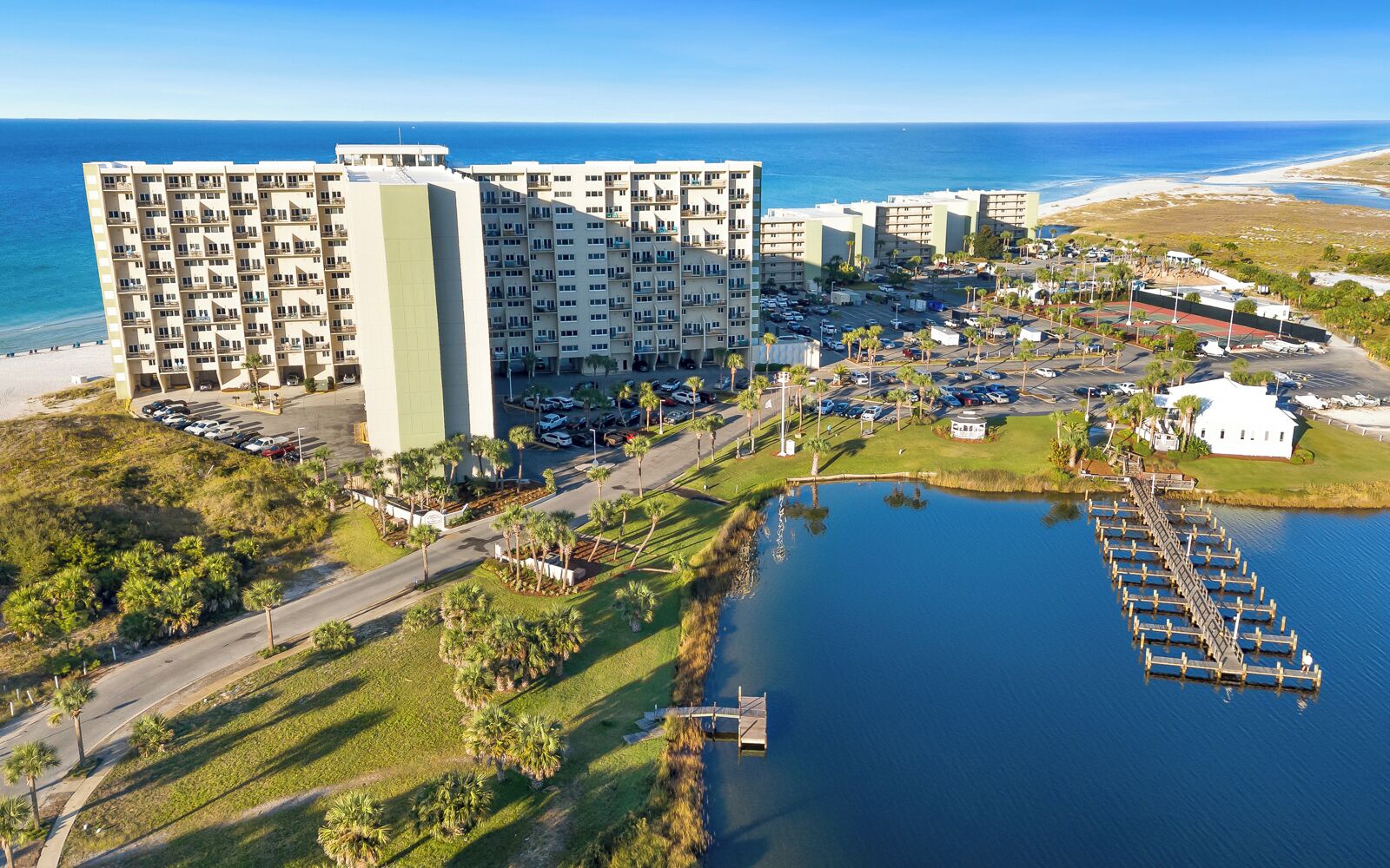 A coastal hotel with multiple buildings, a marina, and a parking lot.