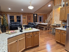 Una cocina acogedora de estilo cabaña con armarios de madera, encimera de granito y zona de comedor con banco de madera.