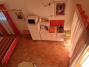 Une cuisine compacte équipée d’un four à micro-ondes, d’un évier et de divers ustensiles de cuisine.