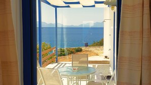 A room with a large window overlooking a scenic view of the sea and mountains. - Sea View Holiday House (Archangelos)