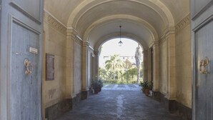 Un corridoio con pavimento in pietra, soffitti a volta e piante in vaso.