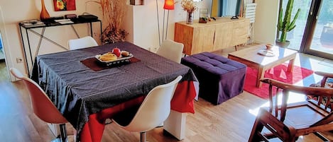 Een moderne eetruimte met een houten tafel, stoelen en een plafondlamp.