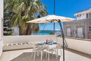 A balcony with a table set for two, overlooking a coastal view. - Sunny Beach - Bilo Ocean by BarbarHouse (Porto Cesareo)