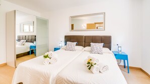 Une chambre d’hôtel avec un grand lit, deux tables de chevet, un miroir et une vue sur l’intérieur de la pièce.