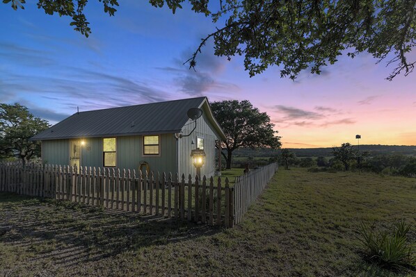 Set amidst rolling fields and trees, this charming house offers a peaceful retreat with a porch and satellite dish.