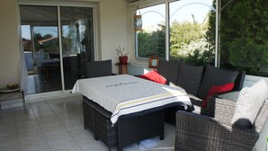 A sunlit patio with a dining table, chairs, and a sofa. - Beautiful 160m² Villa with Heated Pool in Perigny (Perigny)
