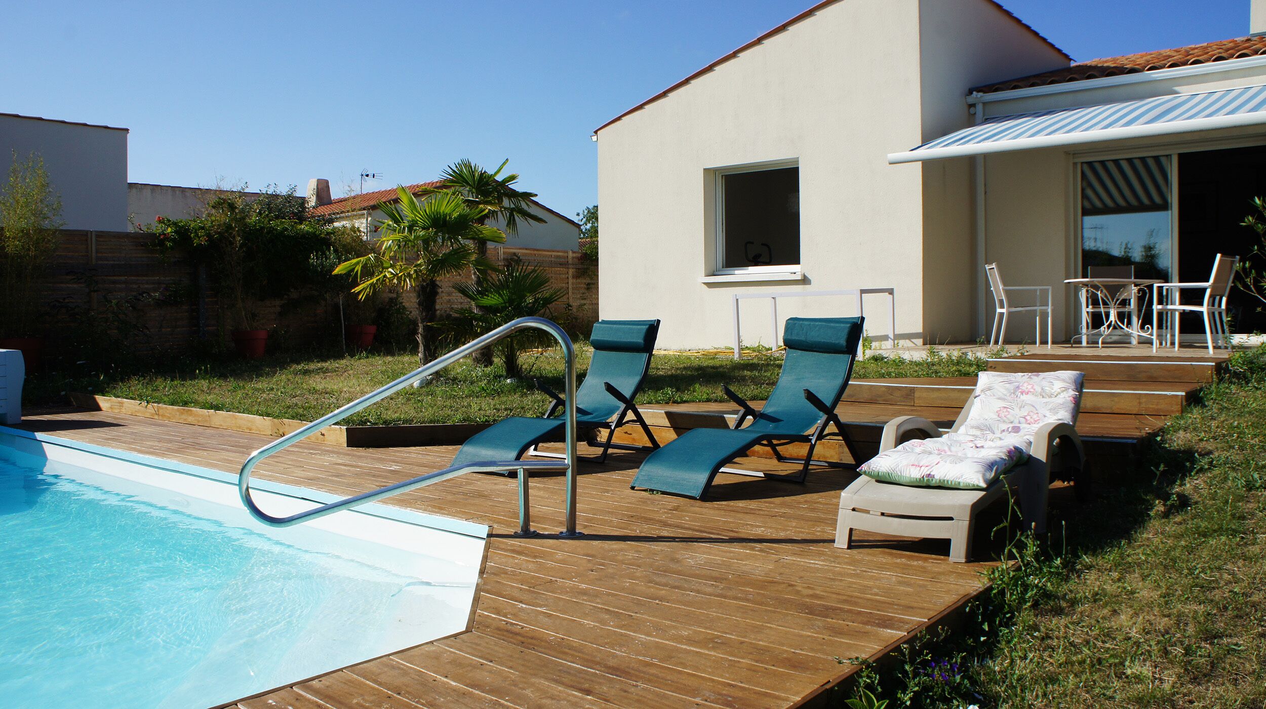 A swimming pool with lounge chairs and a wooden deck.