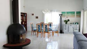 A dining area with a round table and chairs, a bookshelf, and a white cabinet with decorative items. - Beautiful 160m² Villa with Heated Pool in Perigny (Perigny)