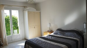 Enjoy a restful stay in this cozy room with a large bed, wardrobe, and bedside table.
