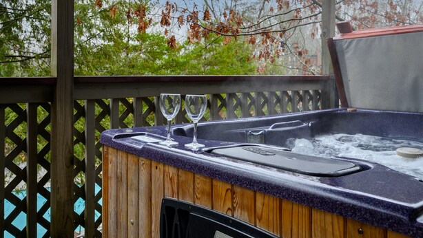 A hot tub with a wooden deck and a wooden fence. - Dollywood Close, Near Pkwy, Hot Tub, Grill, Arcade (Pigeon Forge)