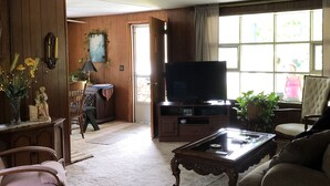 A living room with a television, a coffee table, and a sofa. There is a wooden cabinet and a plant in the corner. -  Reduced to $90.00 March-July week days (Byrnedale)