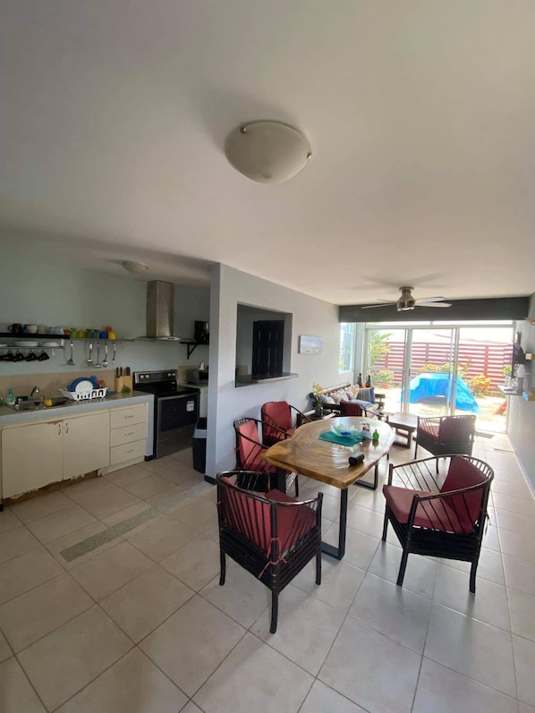 A kitchen with a dining area, featuring a table and chairs, a stove, and a sink.
