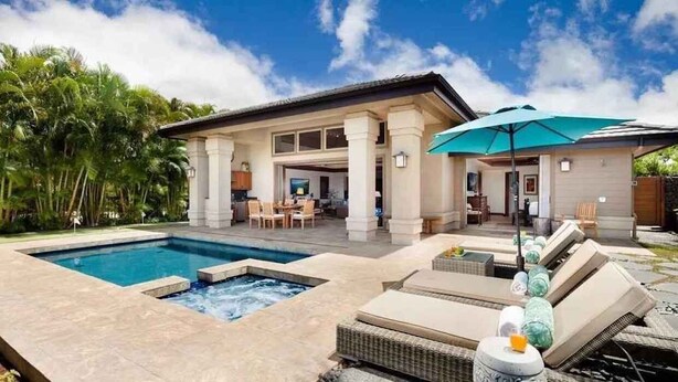 A pool area with lounge chairs and a covered seating area. - Luxury 4 Bedroom with private pool & Spa (Waimea)