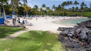 A beach with palm trees, sun loungers, and a clear sky. - Luxury 4 Bedroom with private pool & Spa (Waimea)