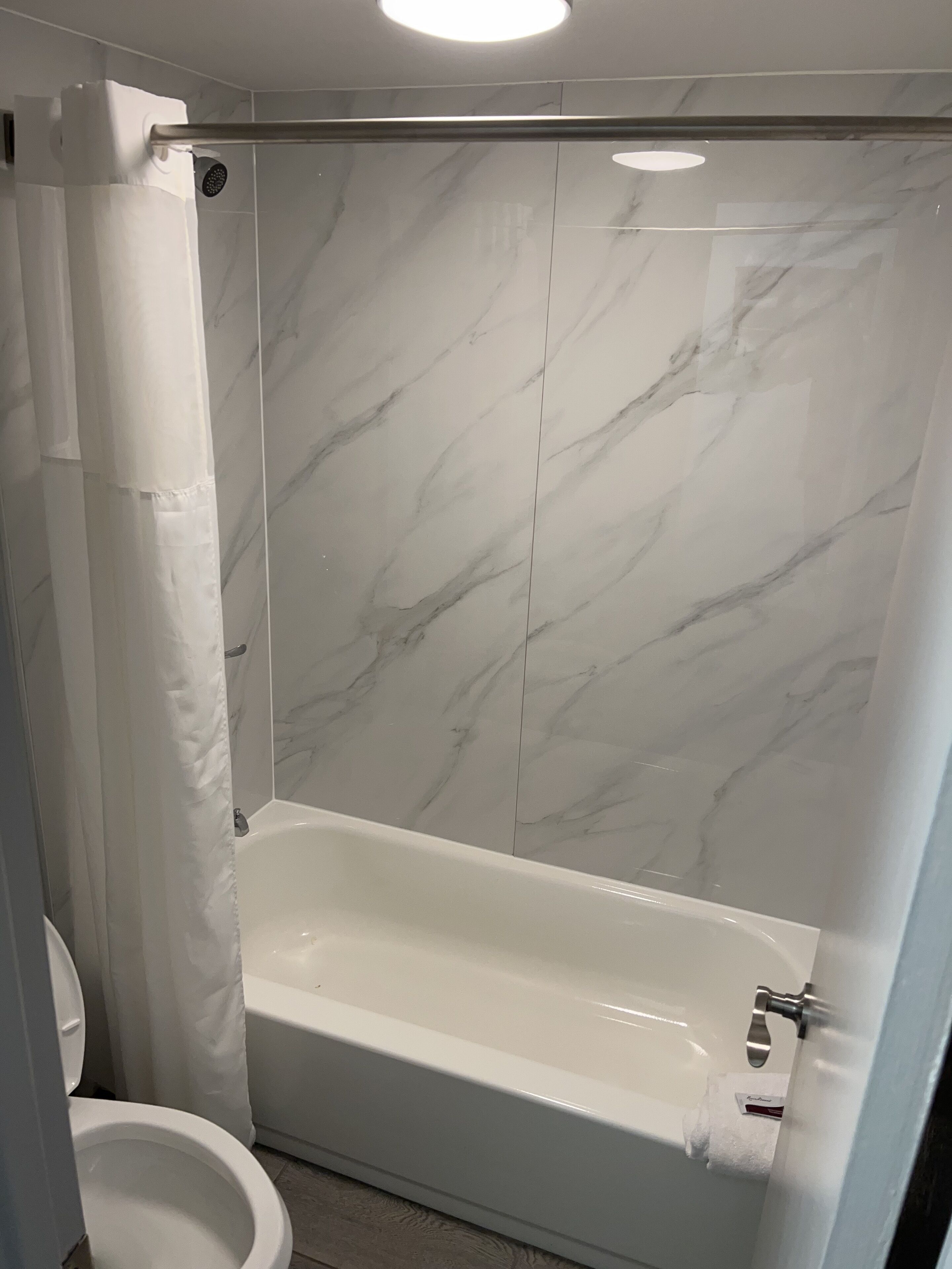 A bathroom with a shower, toilet, and bathtub.