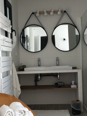 A clean and well-maintained bathroom with a sleek sink, mirror, and towel rack.