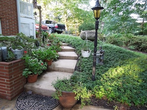 A garden with steps leading to a house, surrounded by greenery and a street lamp. - Quiet Bird River Bungalow and Nature Retreat Pet Friendly  (Middle River)