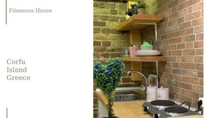 Een kleine keuken met een bakstenen muur, een plant in de vorm van een hart en een fornuis.