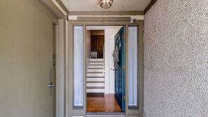 A hallway leading to a staircase with a blue door and a textured wall. - Beautiful family beach townhome getaway (Fernandina Beach)