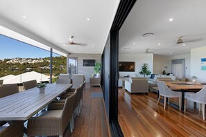 A modern interior with a dining area, sofas, and a kitchen.