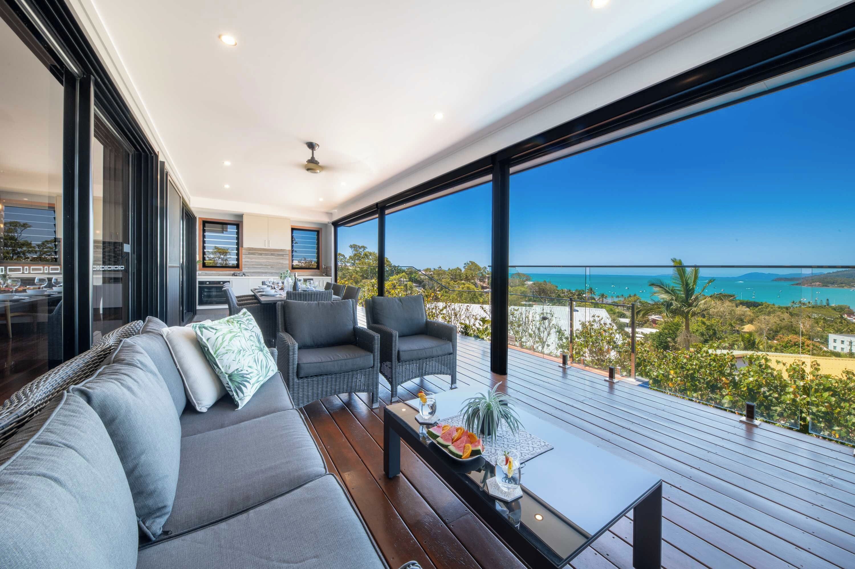 A modern living room with a large window overlooking a coastal view.