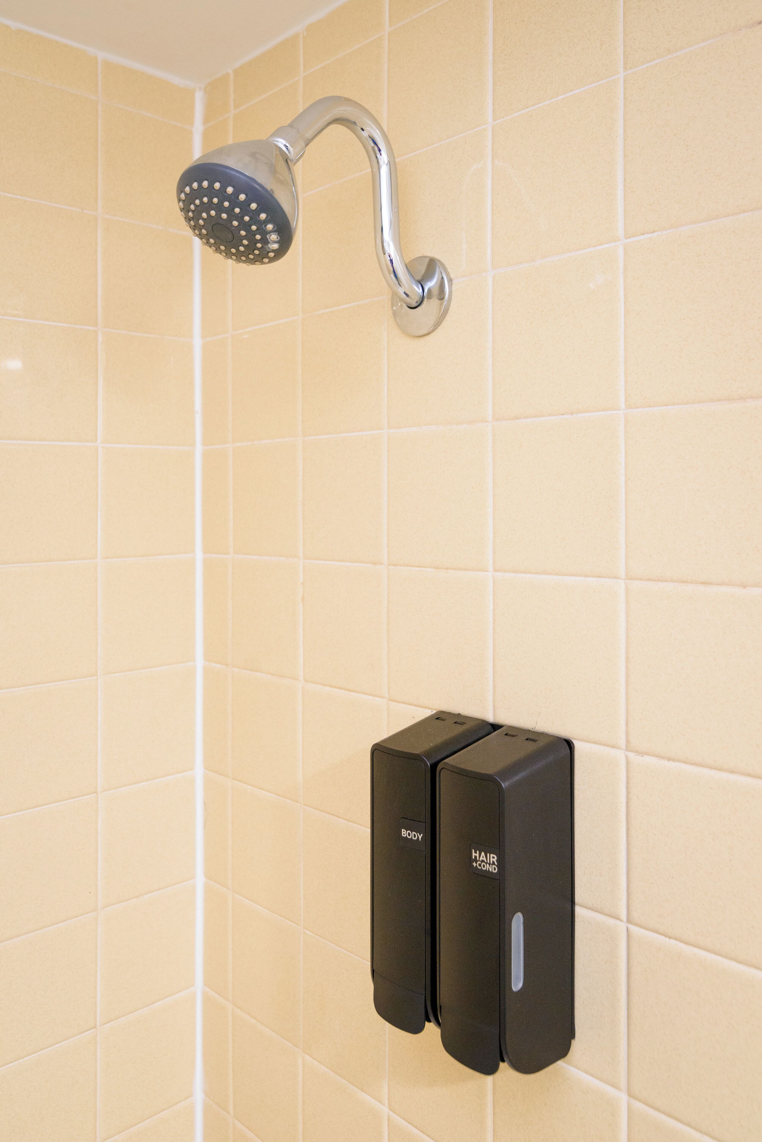 A showerhead mounted on a tiled wall.