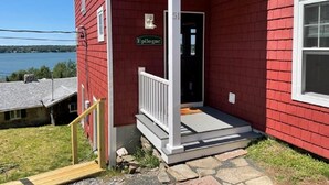 A red house with a porch, a nameplate reading "Epilogue," and a number "51" on the door. - Spacious 3 Bedroom, 2 bath, new home, ocean views, close to Maine seafood! (Orr's Island)