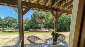 A covered outdoor seating area with wicker furniture and a hanging planter.