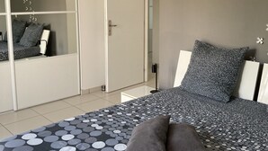 A bedroom with a bed, a wardrobe, and a mirror. - Villa with garden in charming village near Avignon (Entraigues-sur-la-Sorgue)