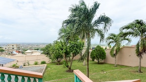 A residential area with a view of a cityscape, including buildings and a distant coastline.