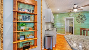 A kitchen with wooden shelves, a trash bin, and a ceiling fan. - Rivers Edge: Spacious, Riverwalk, Close to USC, Ft Jackson, all area Hospitals (West Columbia)