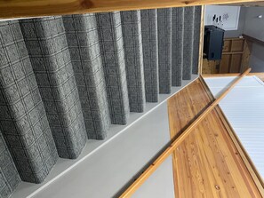 Stunning staircase with a wooden handrail and metal railing, set against a textured, patterned backdrop.